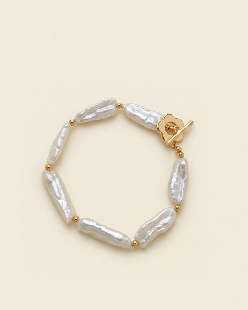 Pearl bracelet with gold clasp on a beige background