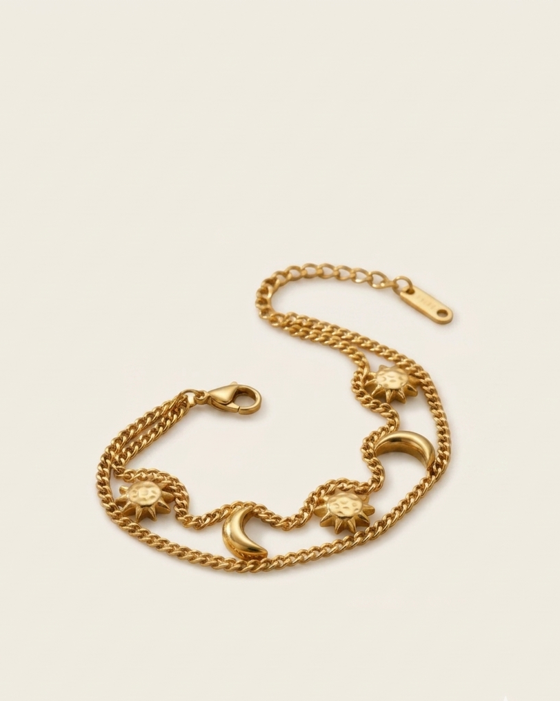 Gold chain bracelet with decorative elements on a beige background
