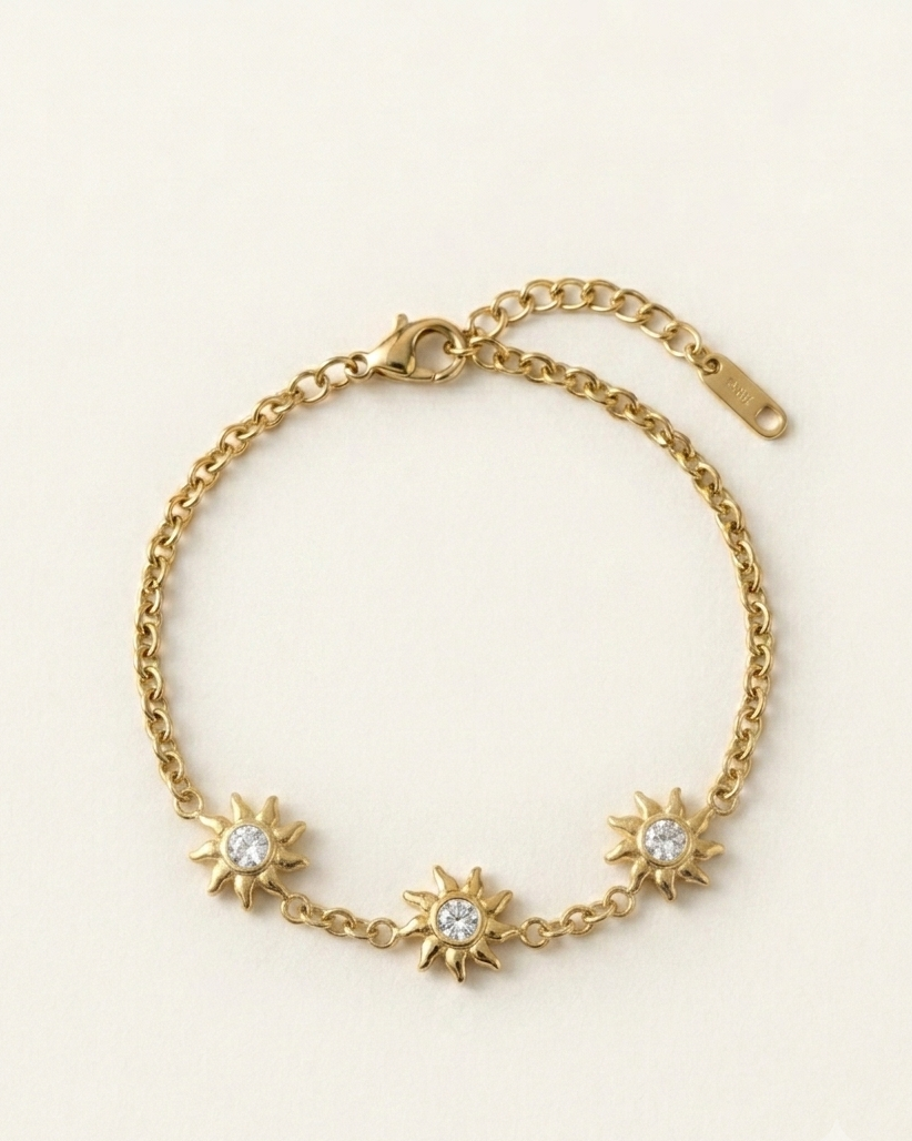 Gold bracelet with sunflower designs on a beige background