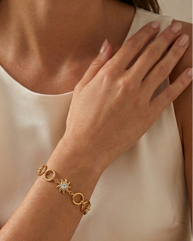 Woman wearing a gold bracelet with star design on a neutral background