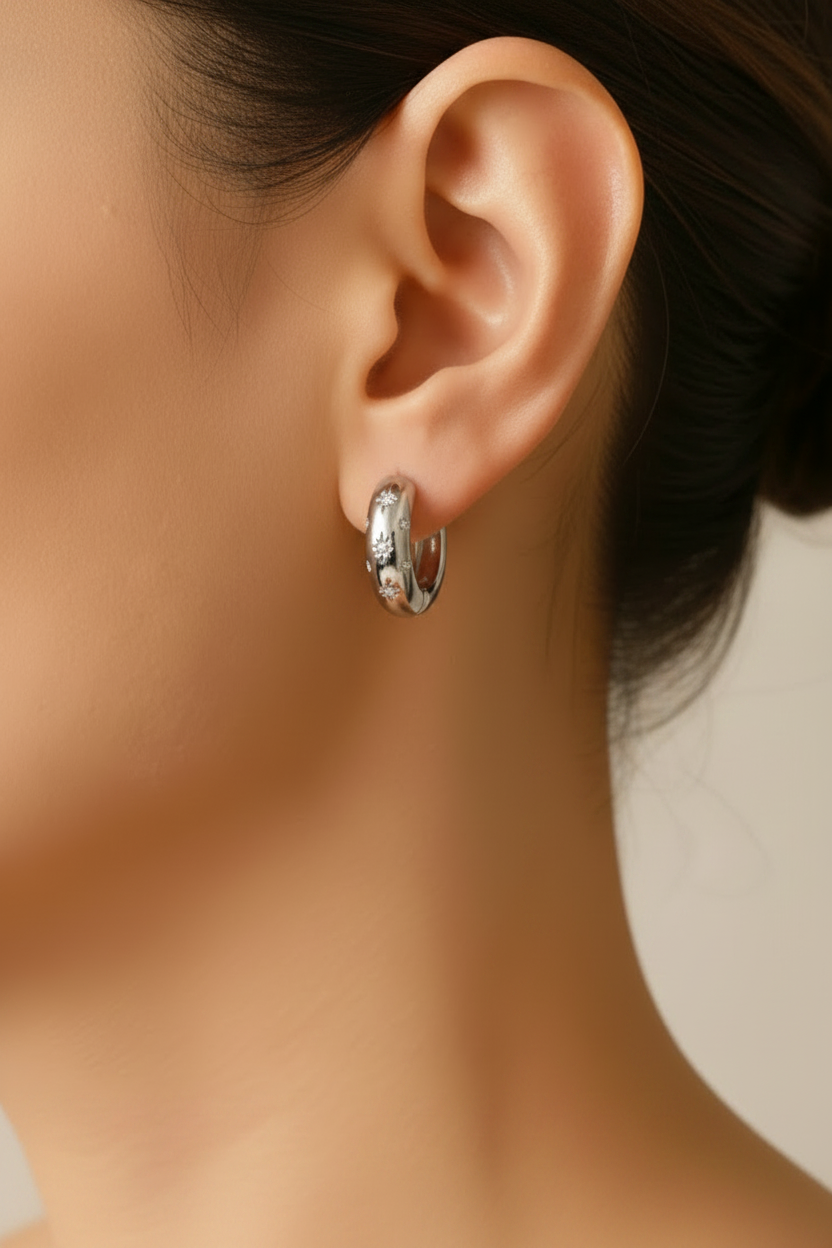 silver hoop earrings worn by a person with a neutral background